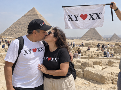 Couple sharing a kiss near the pyramids with a hanging TSF flag.