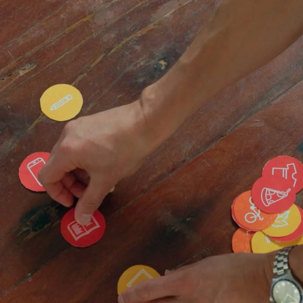 A hand moving around coloured circles on a table