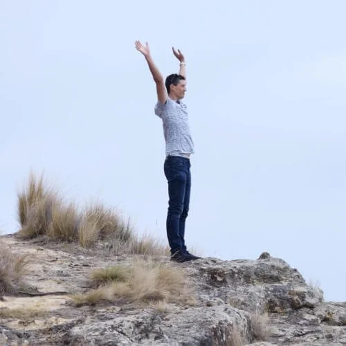 Daniel outside with his arms raised, with text 'Saying yes'