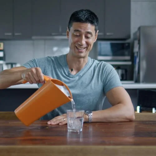 Daniel pours water from an orange jug into a glass, with text 'Making space'