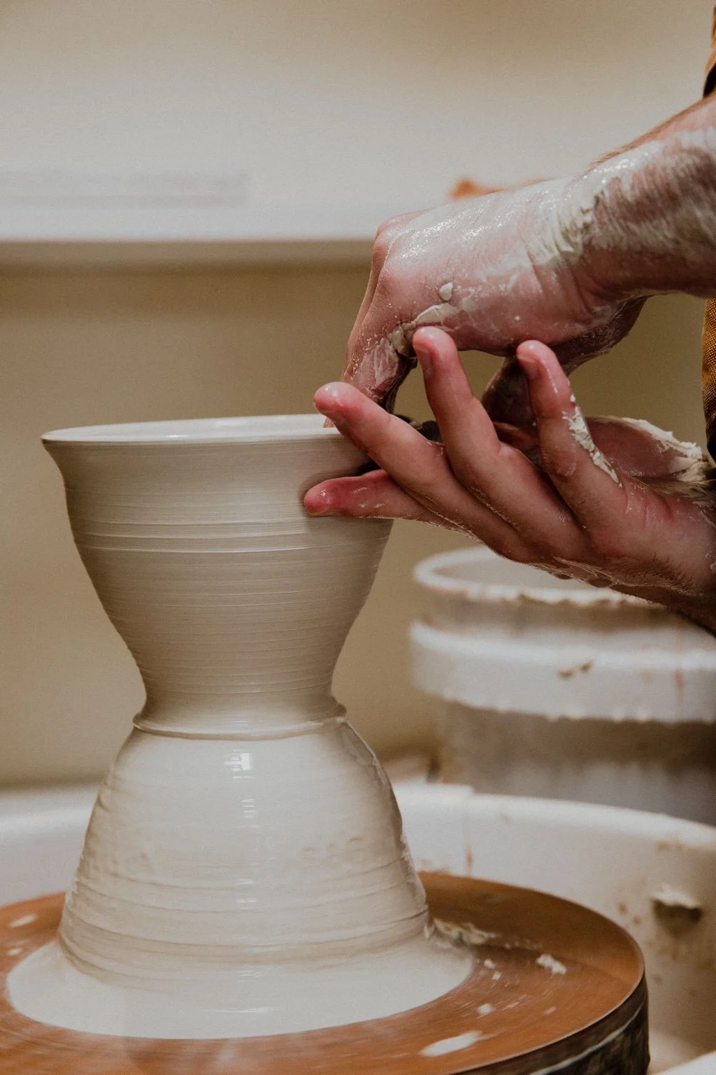 John shaping a small vessel on the wheel