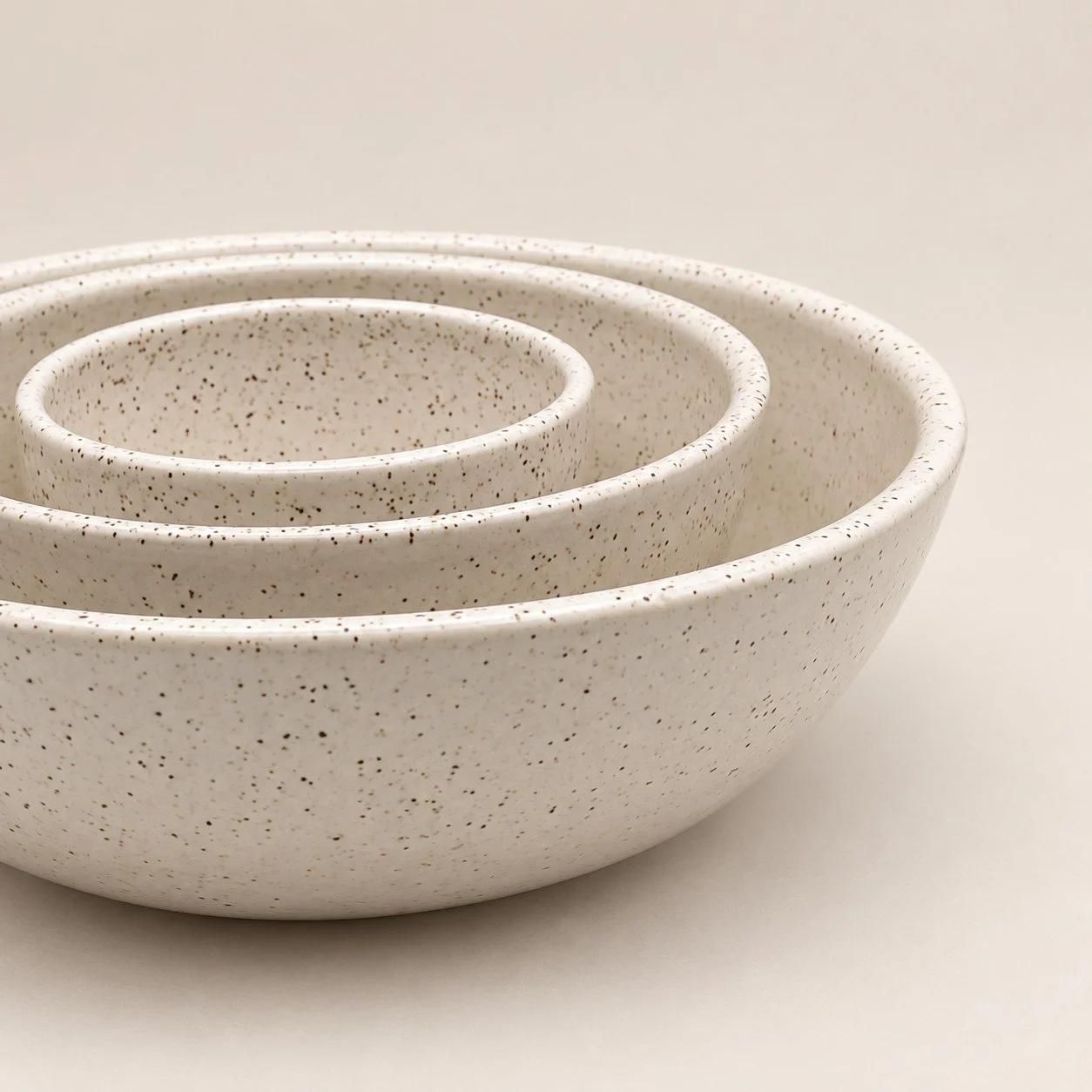 Nested fully glazed speckled white bowls