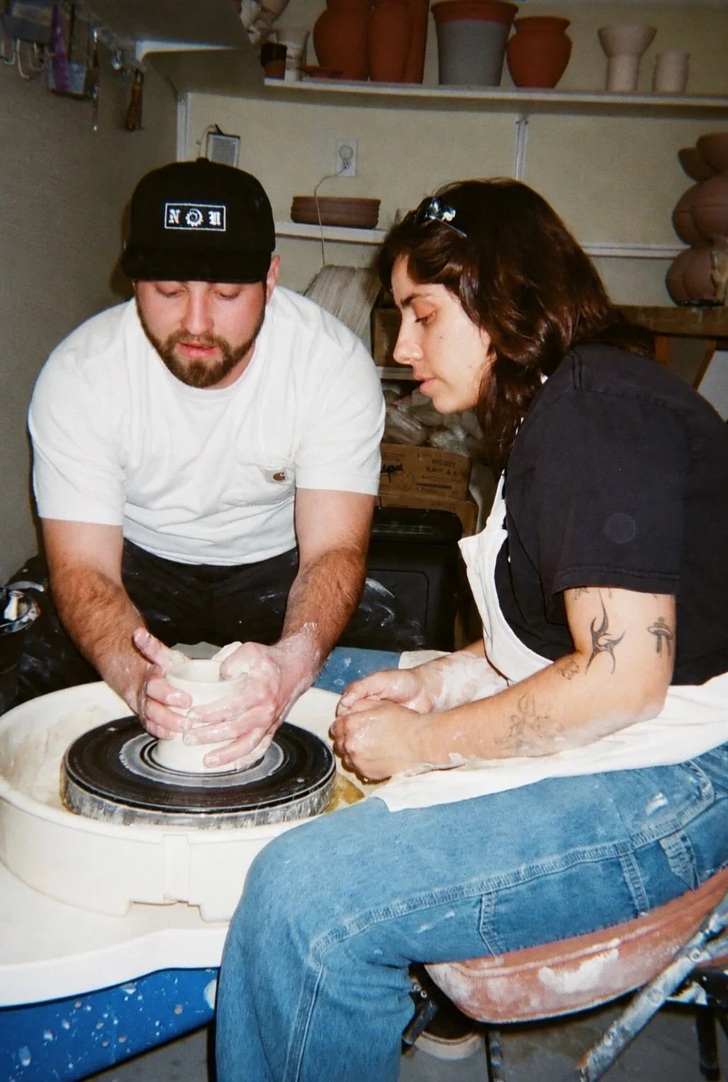 John Jaspert guiding a student at the pottery wheel in his Vista studio