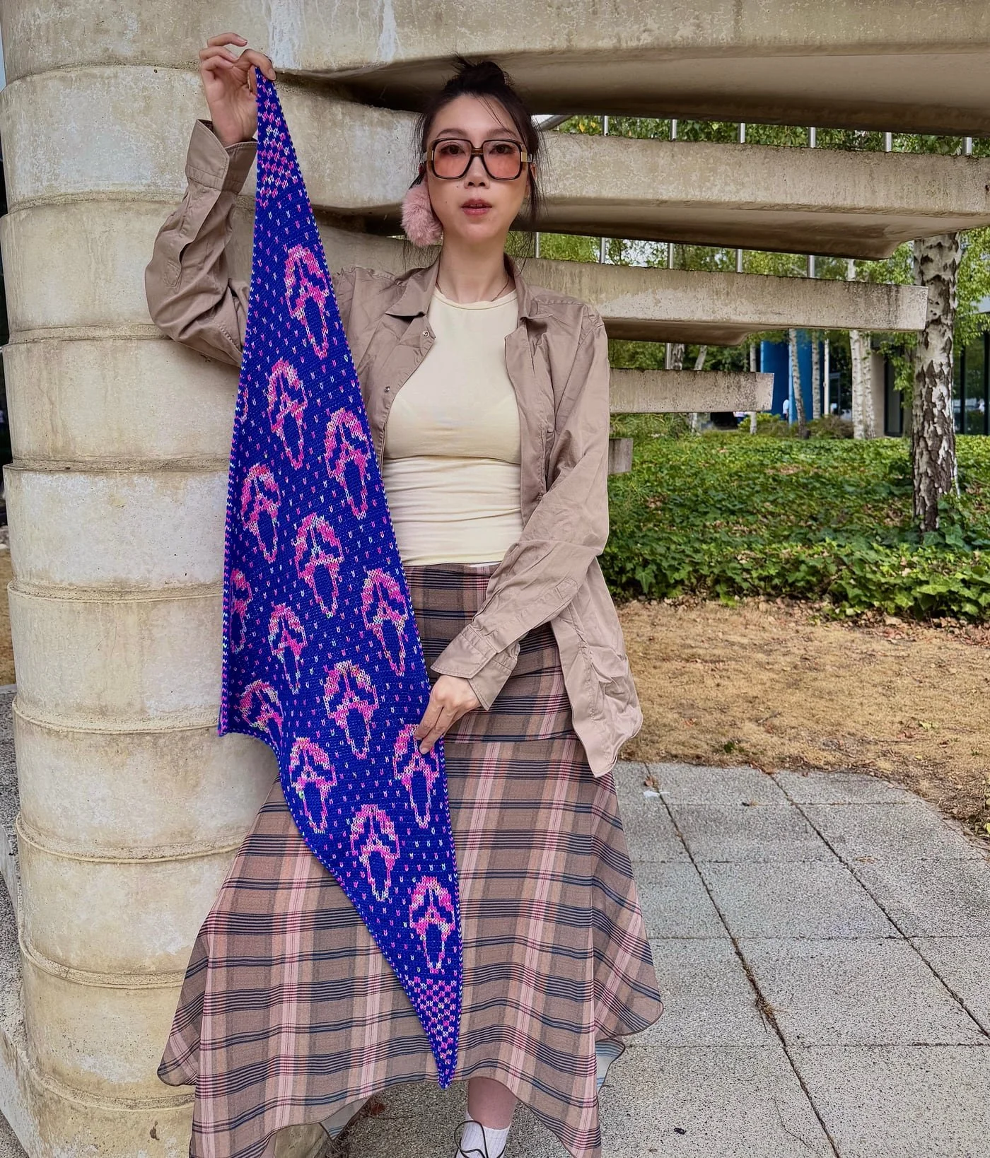 The blue and pink Slasher scarf held open against a concrete spiral staircase