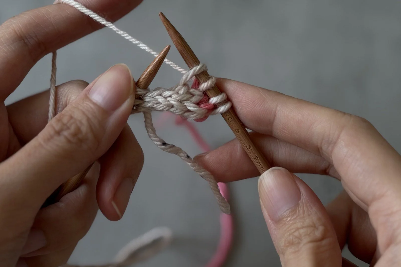 The needle transferring the white centre stitch with both working yarns behind.