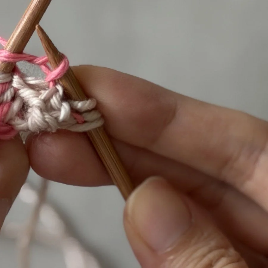 Close-up of the pink MC knit stitch in the centre pair on the Side B setup row.