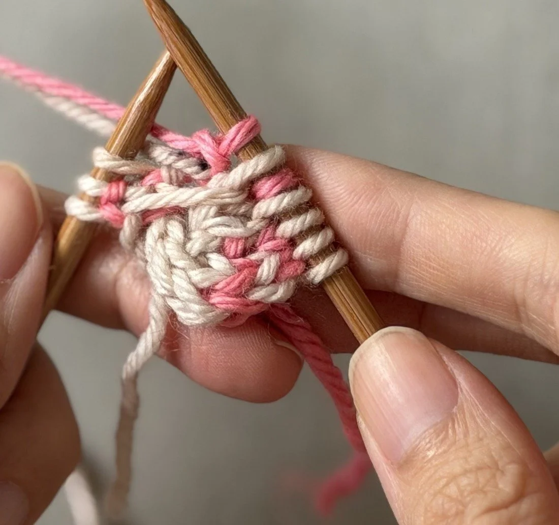 Close-up: The completed CC knit and MC purl increase pair immediately inside the I-cord edge.