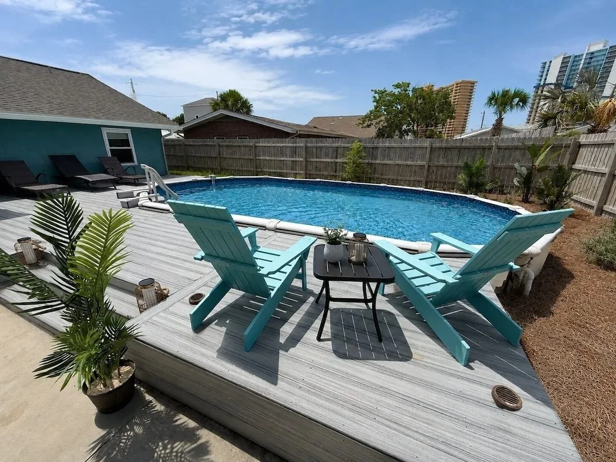 Private backyard pool with lounge chairs and a fenced deck at Opal Oasis