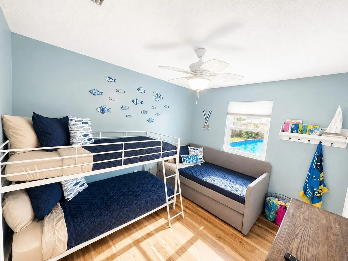 Family bunk room with twin bunks, daybed, and pool view