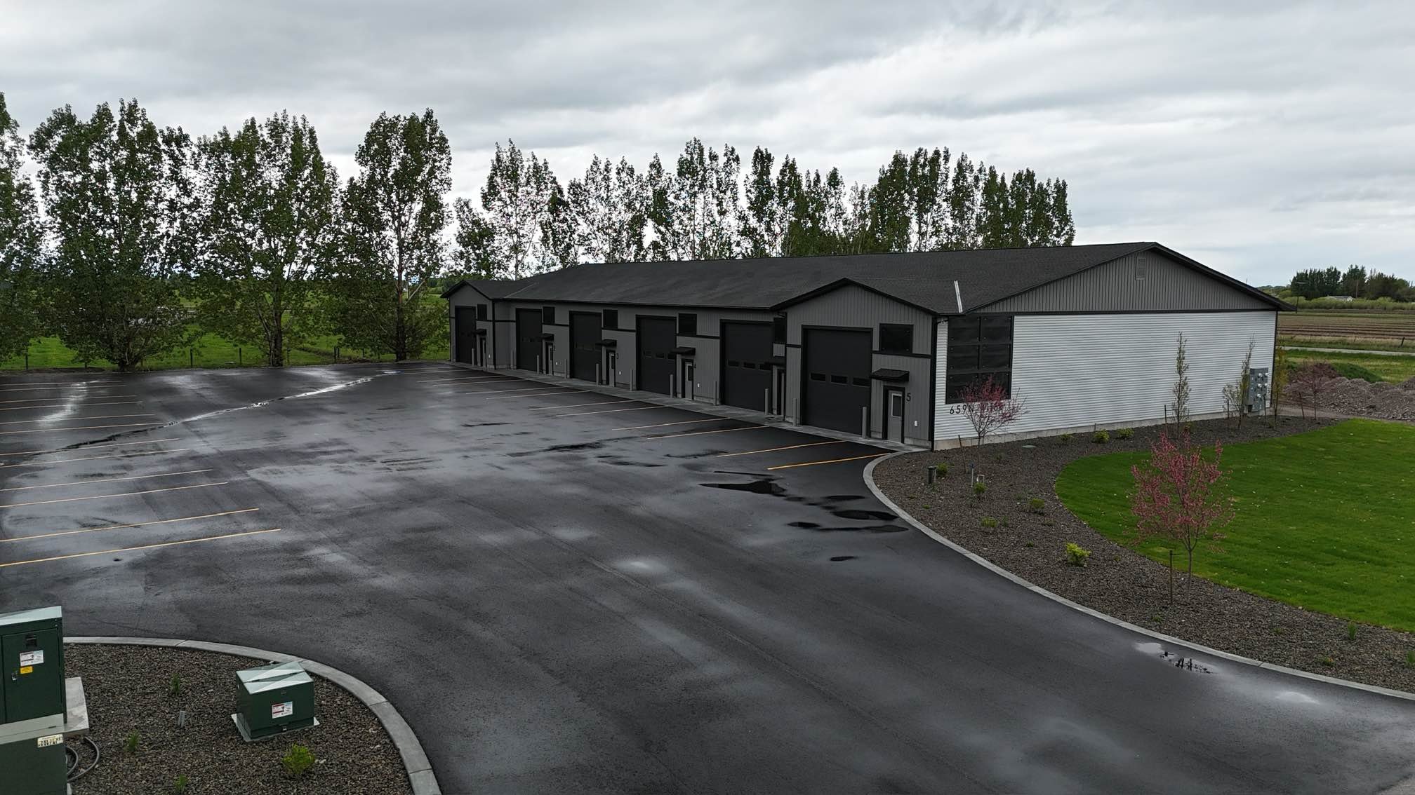 Buku Properties commercial units with overhead garage doors and a paved parking lot