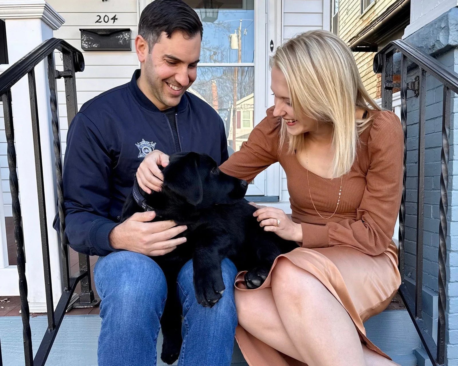 Danny Ceisler with his wife Helen and their puppy Bruce on the front steps of their home in Bristol Borough