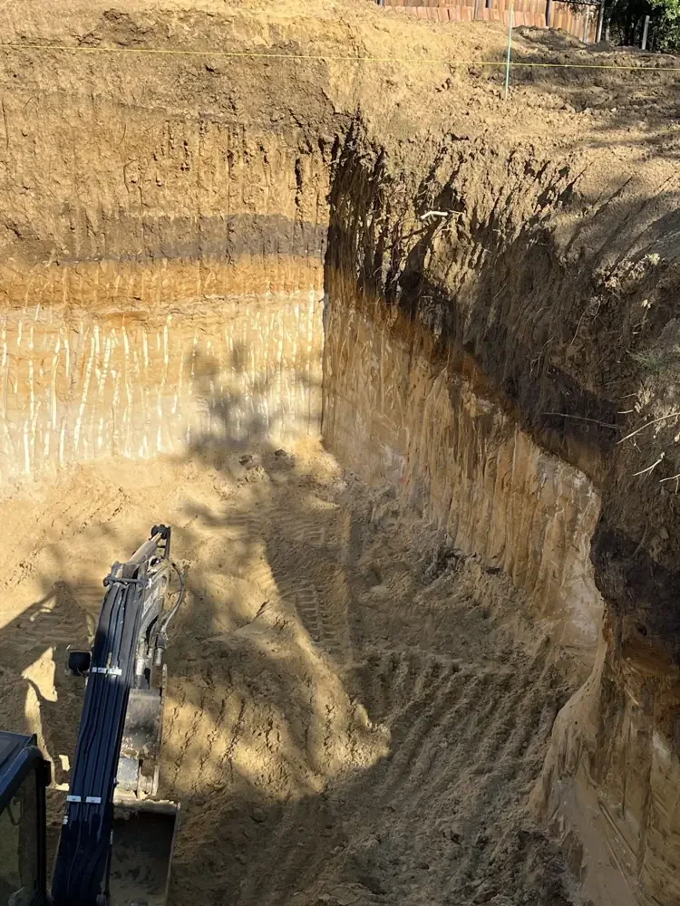 Newly added original field photograph looking into the Life Safety Shelter Lux sandy excavation, with the excavator boom below