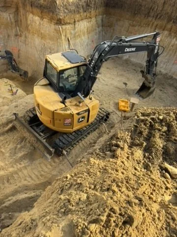 Original close view of the Deere excavator tracks, cab and bucket inside Life Safety Shelter Lux