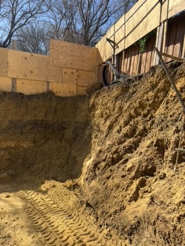 Ground-level Life Safety Shelter Lux excavation photograph showing the sandy floor and equipment tracks
