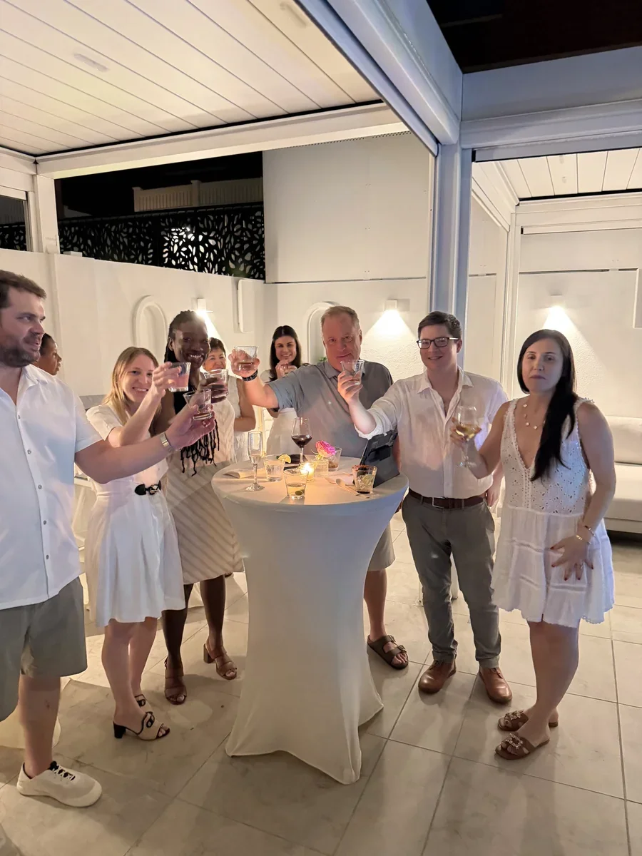 A group raising their glasses around a cocktail table.