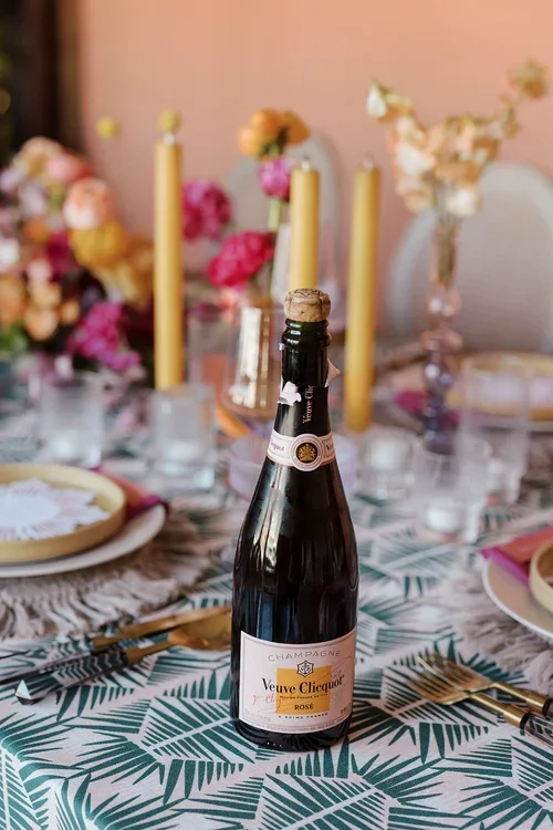 Champagne bottle on a colorful, artfully designed wedding table