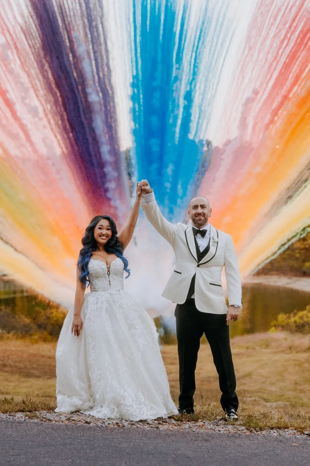 Newlyweds celebrating beneath a colorful installation
