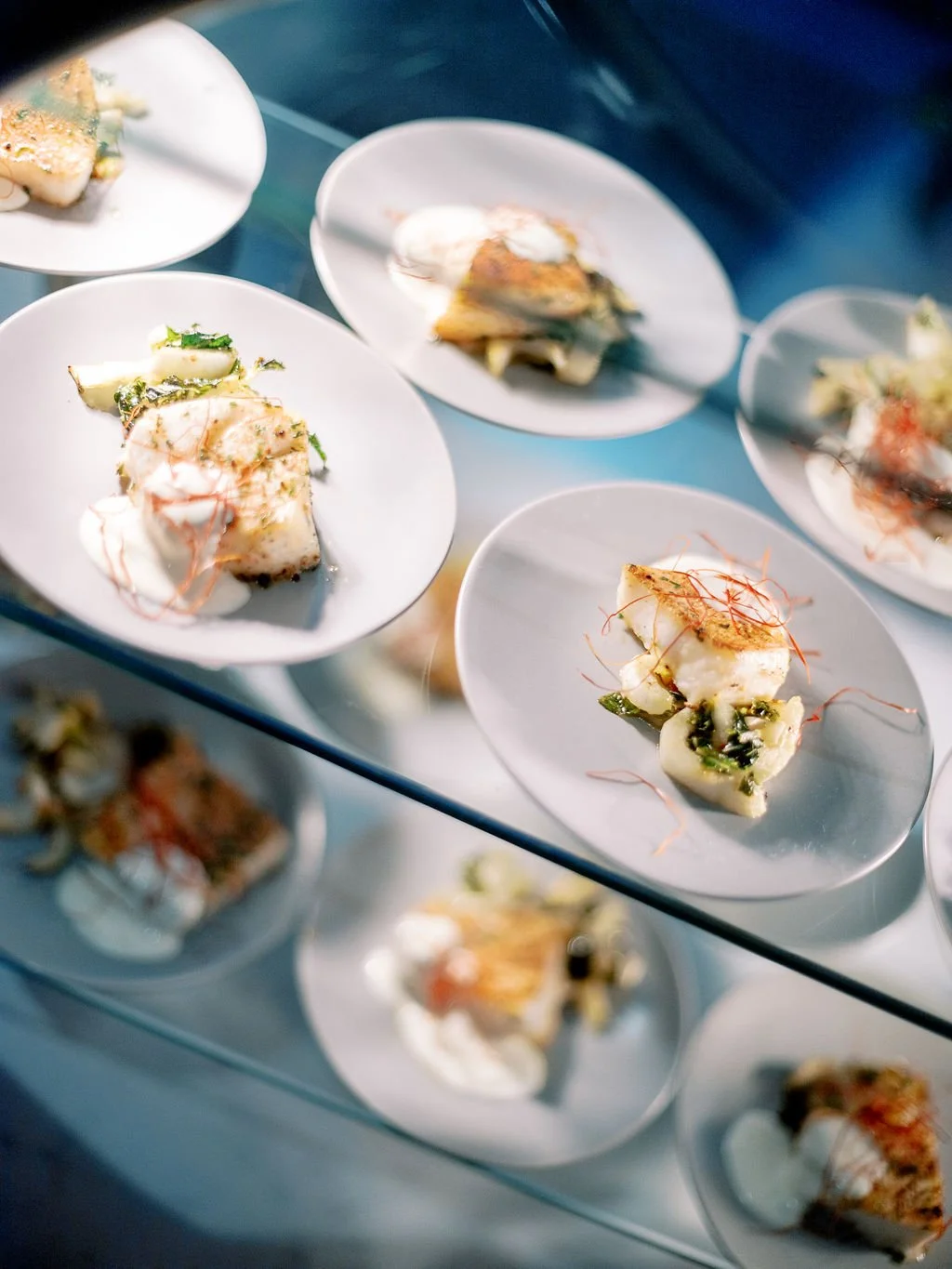 Artfully plated small dishes on a glass display
