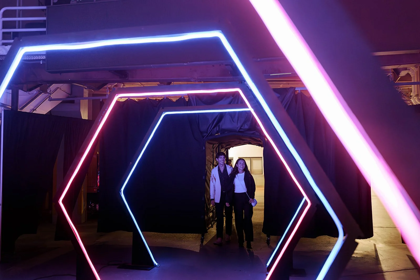 Guests entering illuminated geometric arches