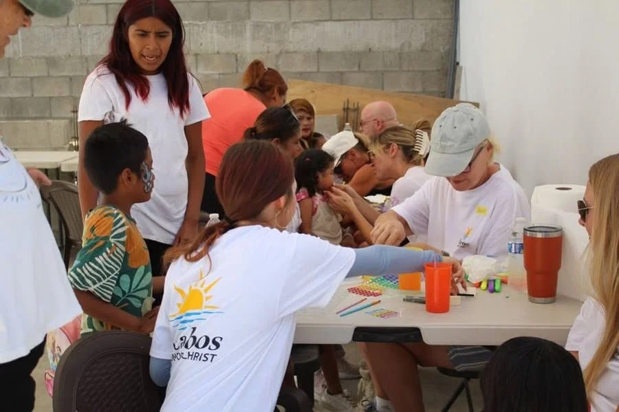 Volunteers and children creating crafts and painting faces at the Community Center.