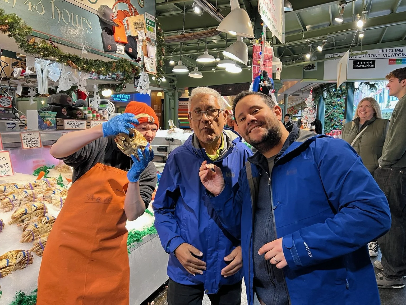 A fish vendor and Cascade guests smiling at Pike Place Market