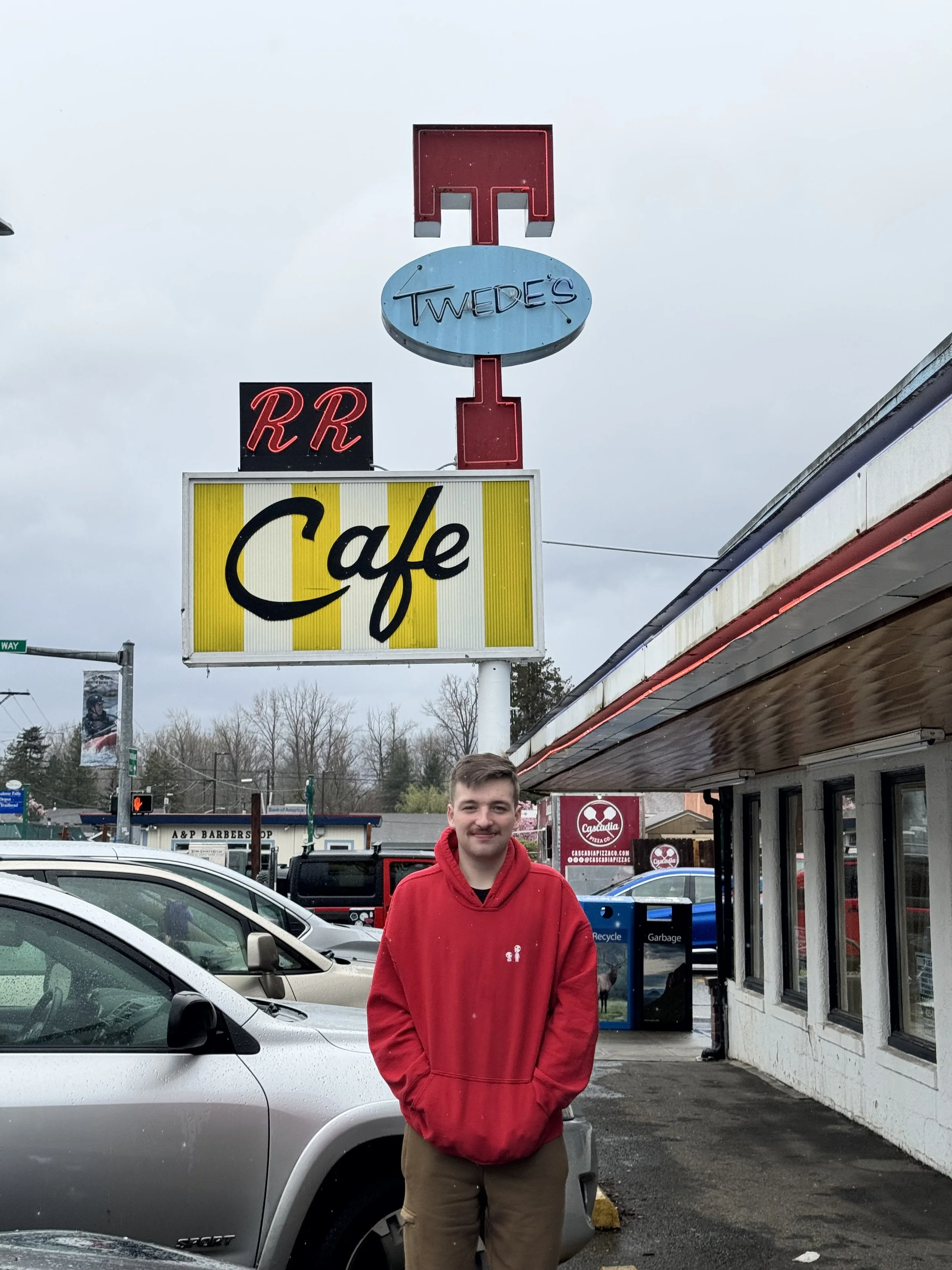 A guest outside Twede’s Café beneath the Double R sign