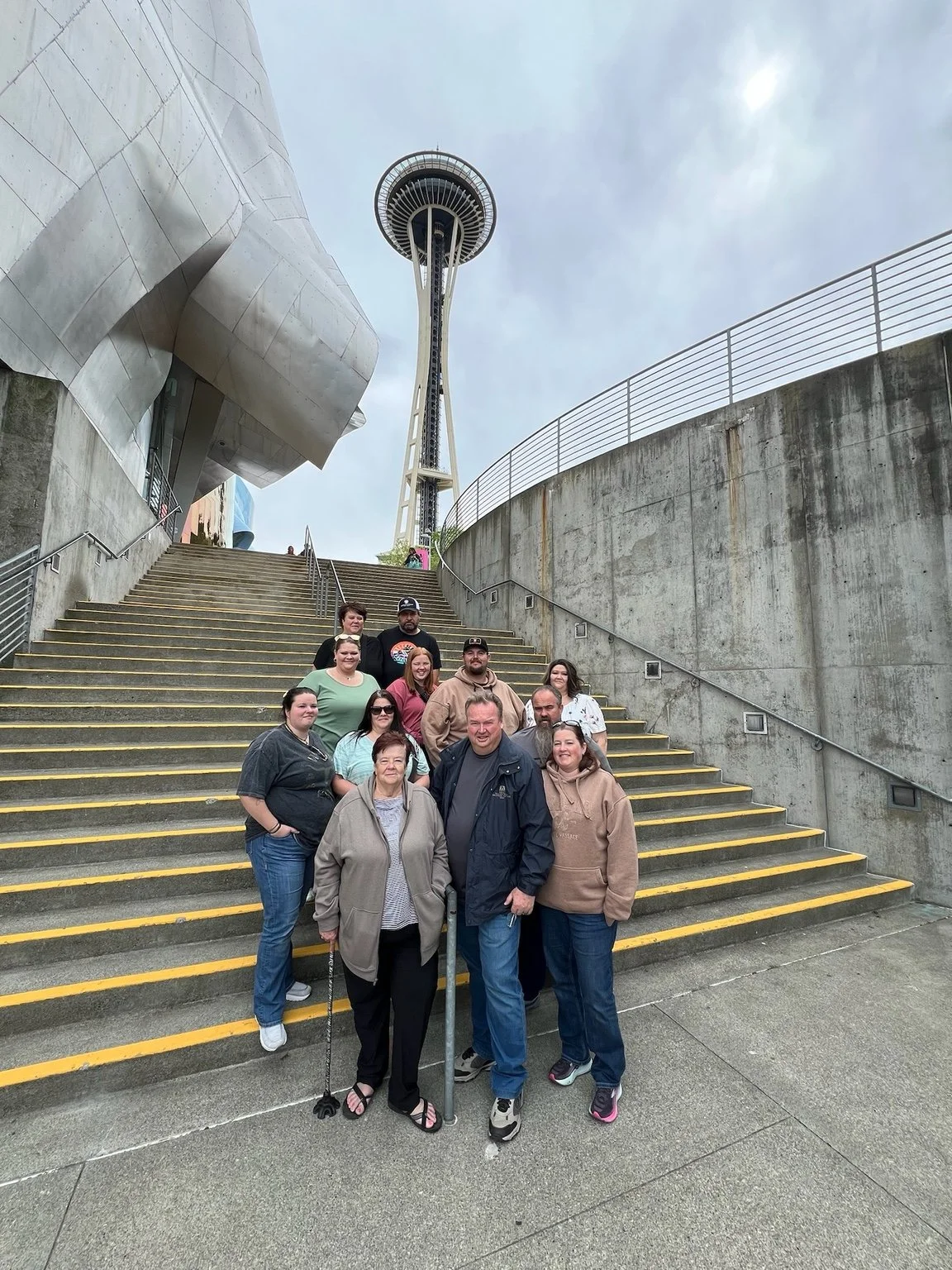 A family on the MoPOP steps beneath the Space Needle