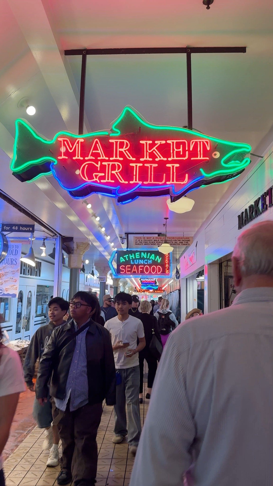 Children exploring the neon-lit aisles of Pike Place Market