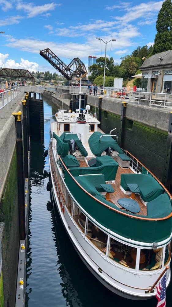 A boat inside Ballard Locks with lock walls and the raised railway bridge