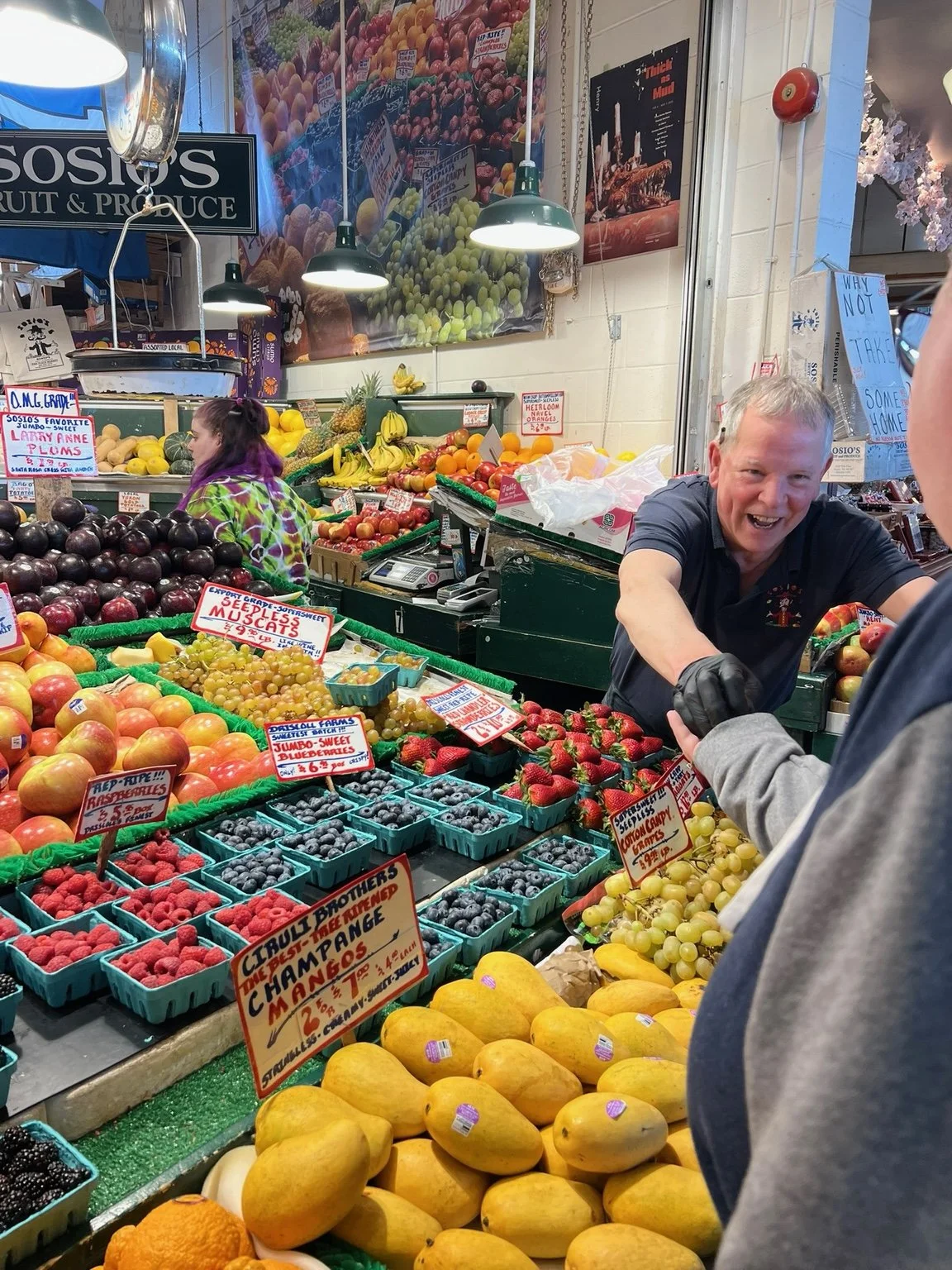 Colorful produce and a friendly vendor at Pike Place Market
