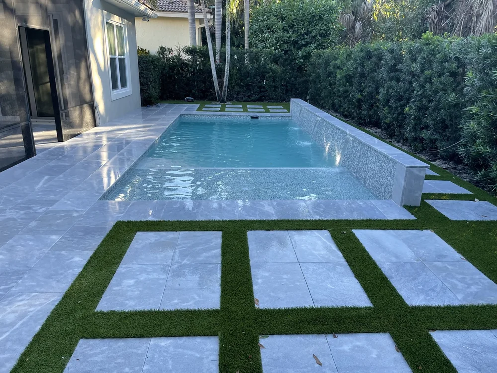 Rectangular pool with travertine deck and turf inlays
