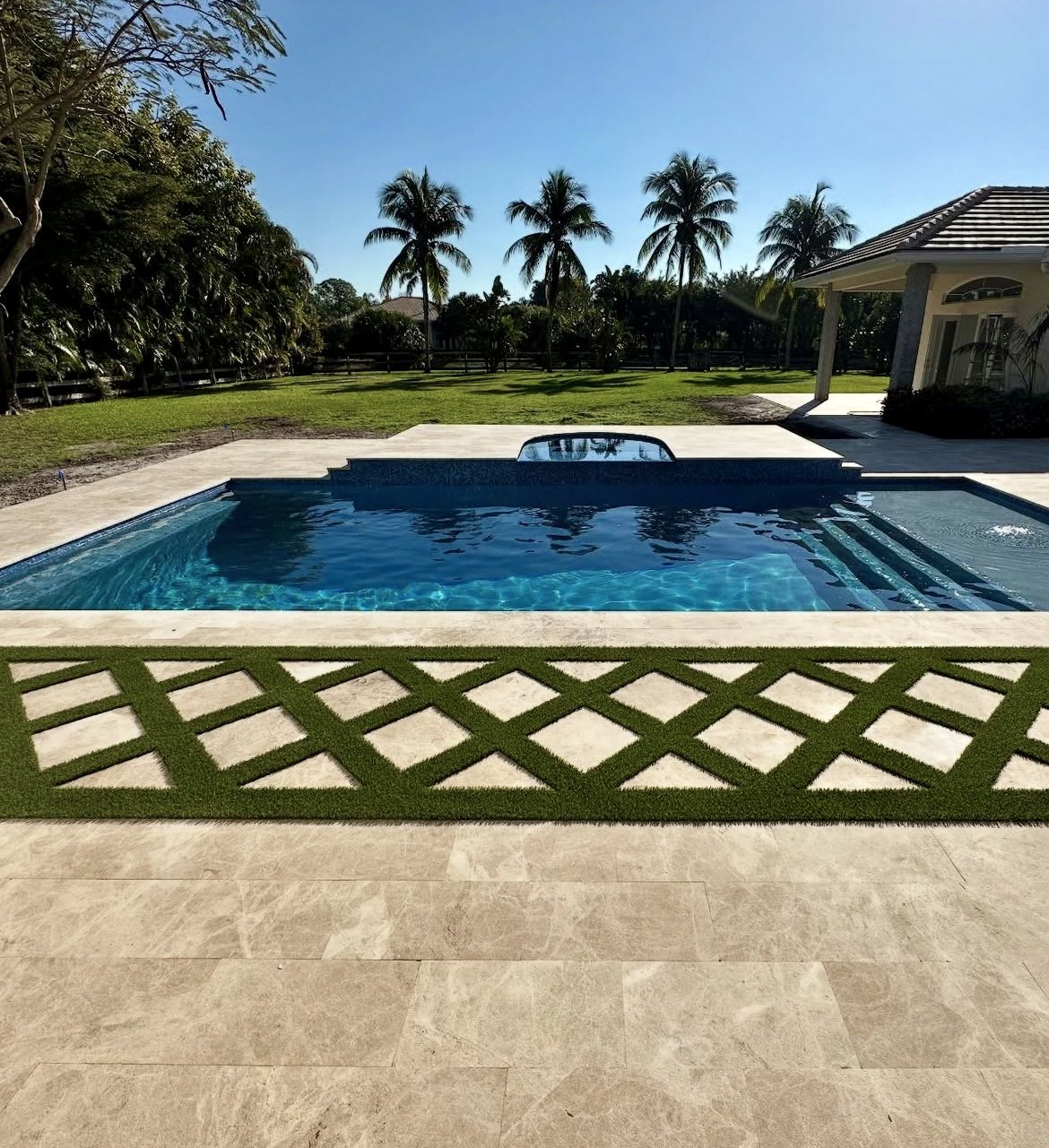 Sunset over a new Oasis pool with a pergola and lounge chairs