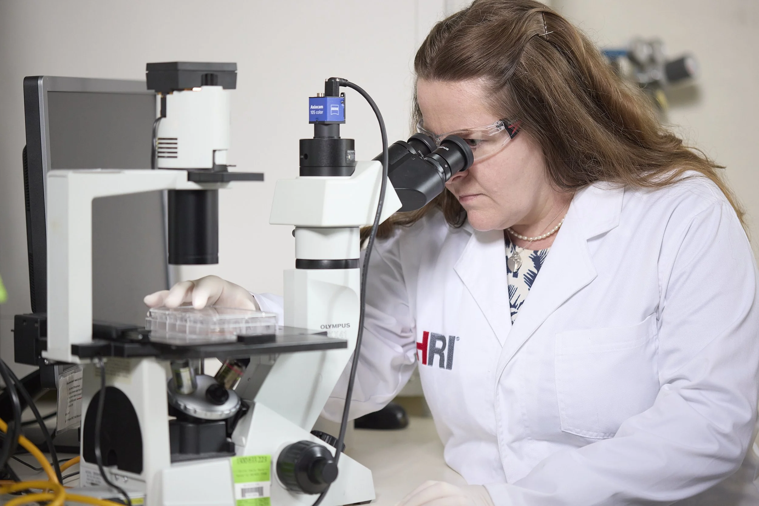 Heart Research Institute scientist looking through a microscope in the lab