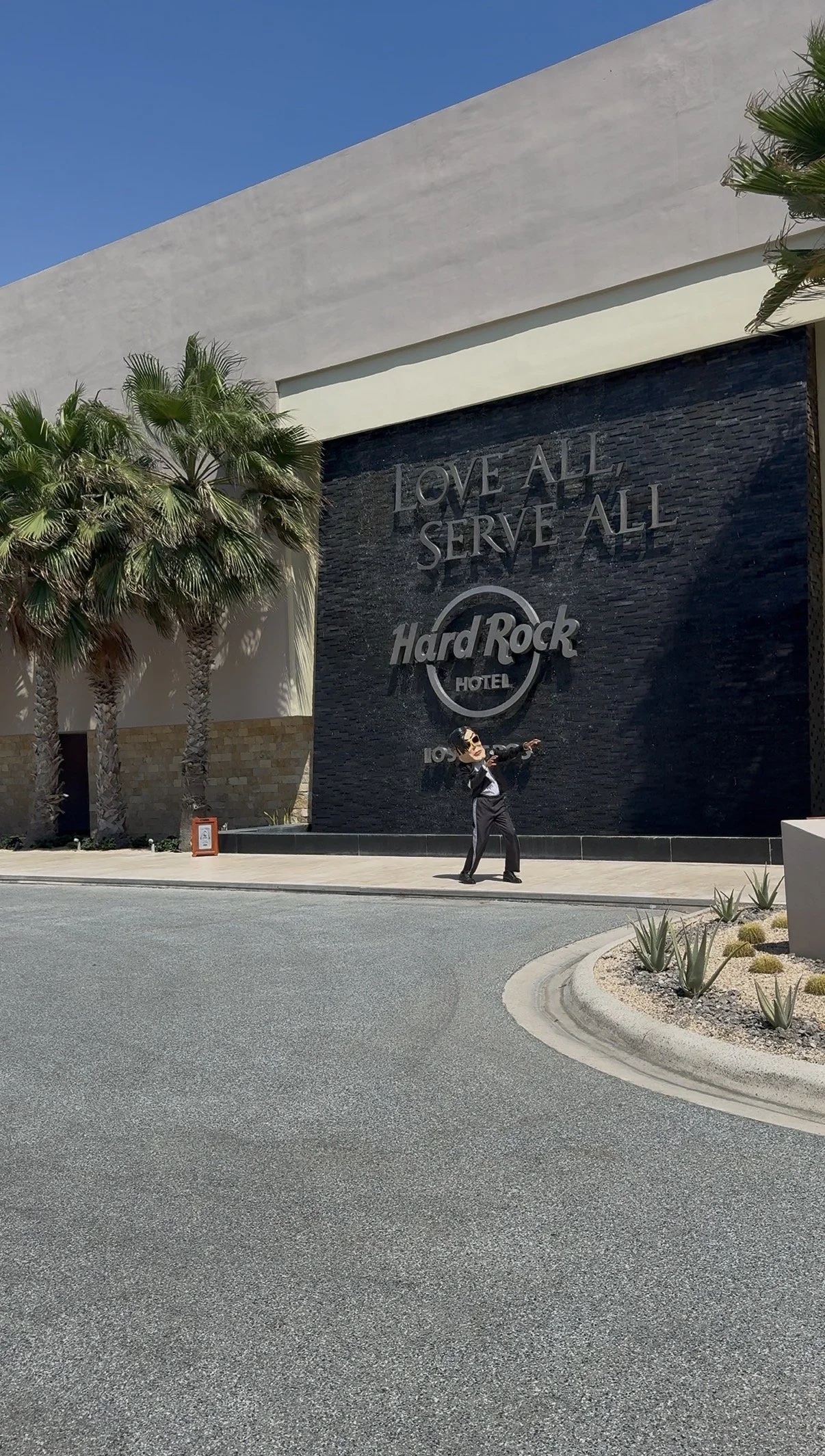 Leyanis Diaz outside the Hard Rock Hotel Los Cabos entrance and Love All Serve All sign