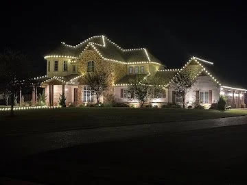 Warm white roofline lighting on a large home