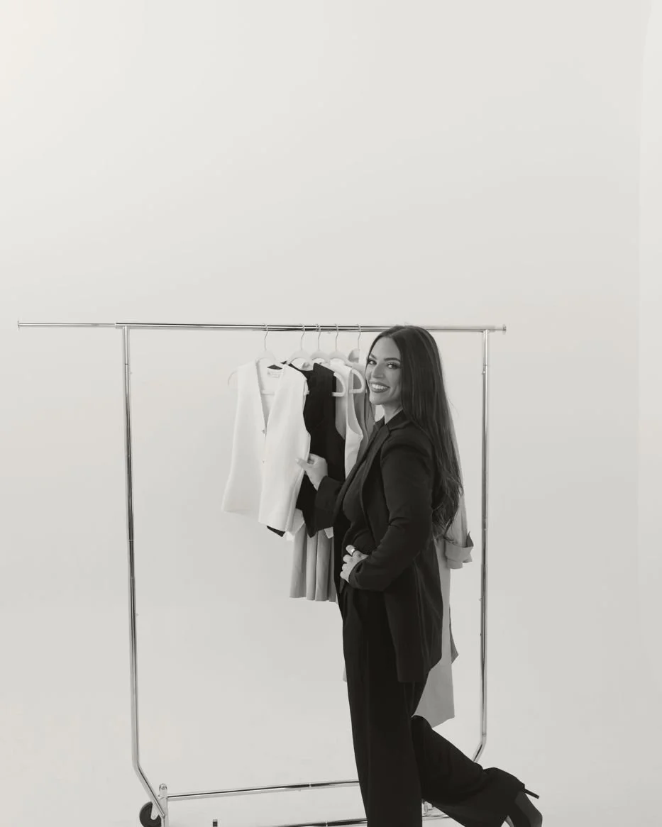 Nicole Marcus, founder of MARCETING HOUSE, beside a clothing rack in the studio
