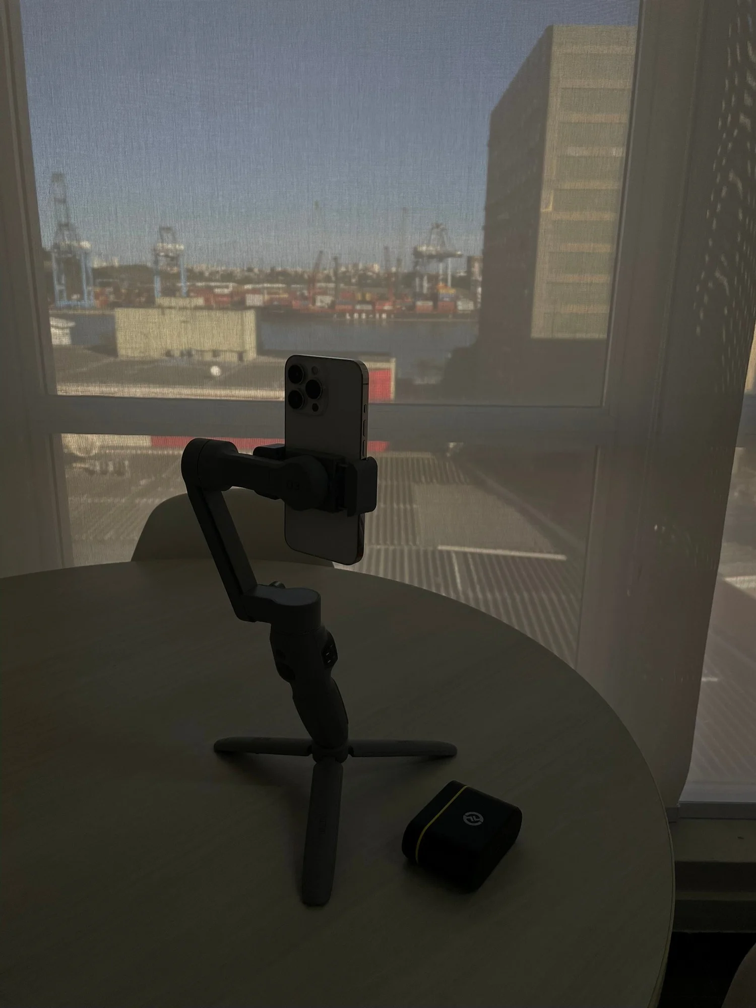 A phone on a gimbal, set up to film by a bright window