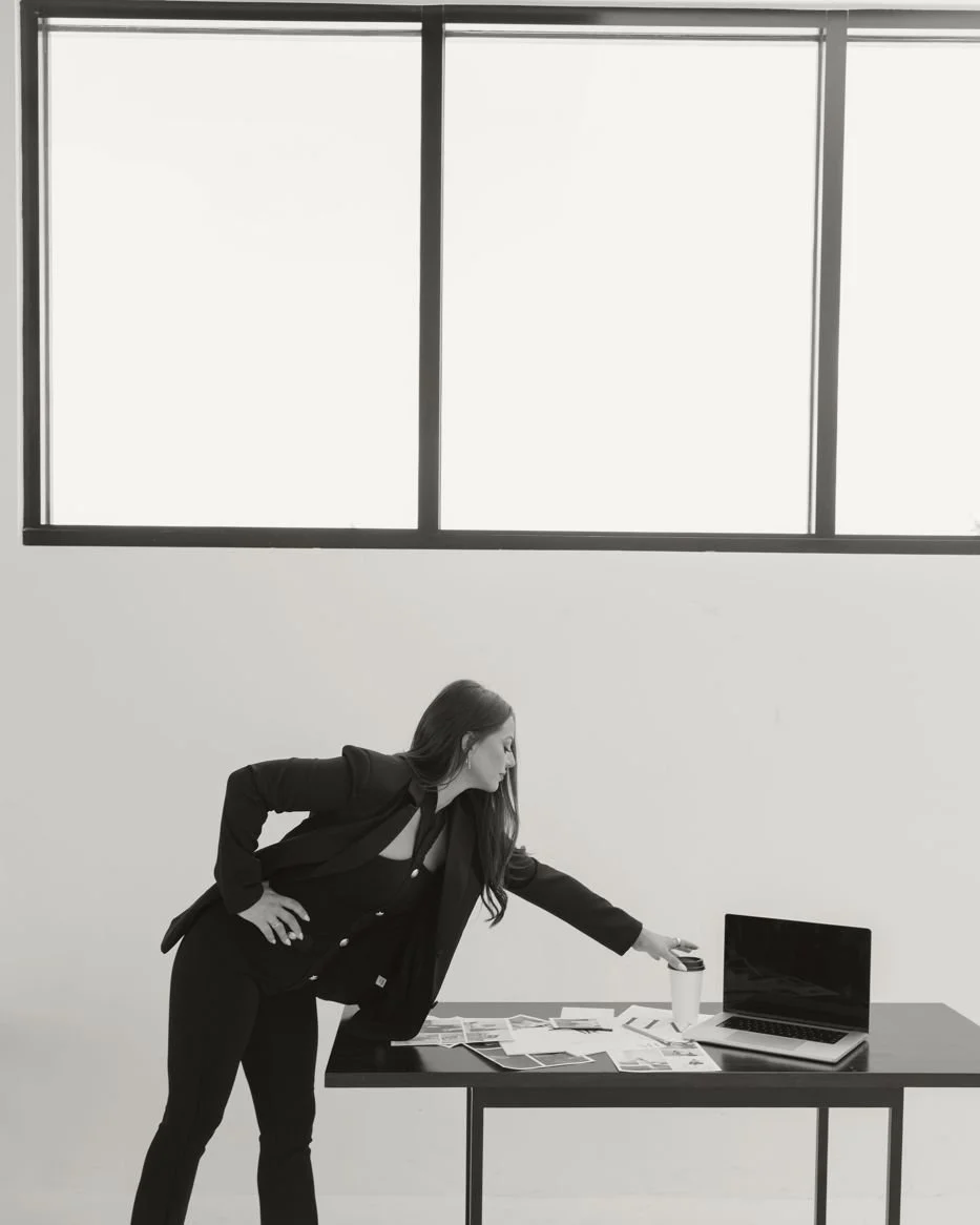 Nicole Marcus, founder of MARCETING HOUSE, leaning on a desk with a laptop