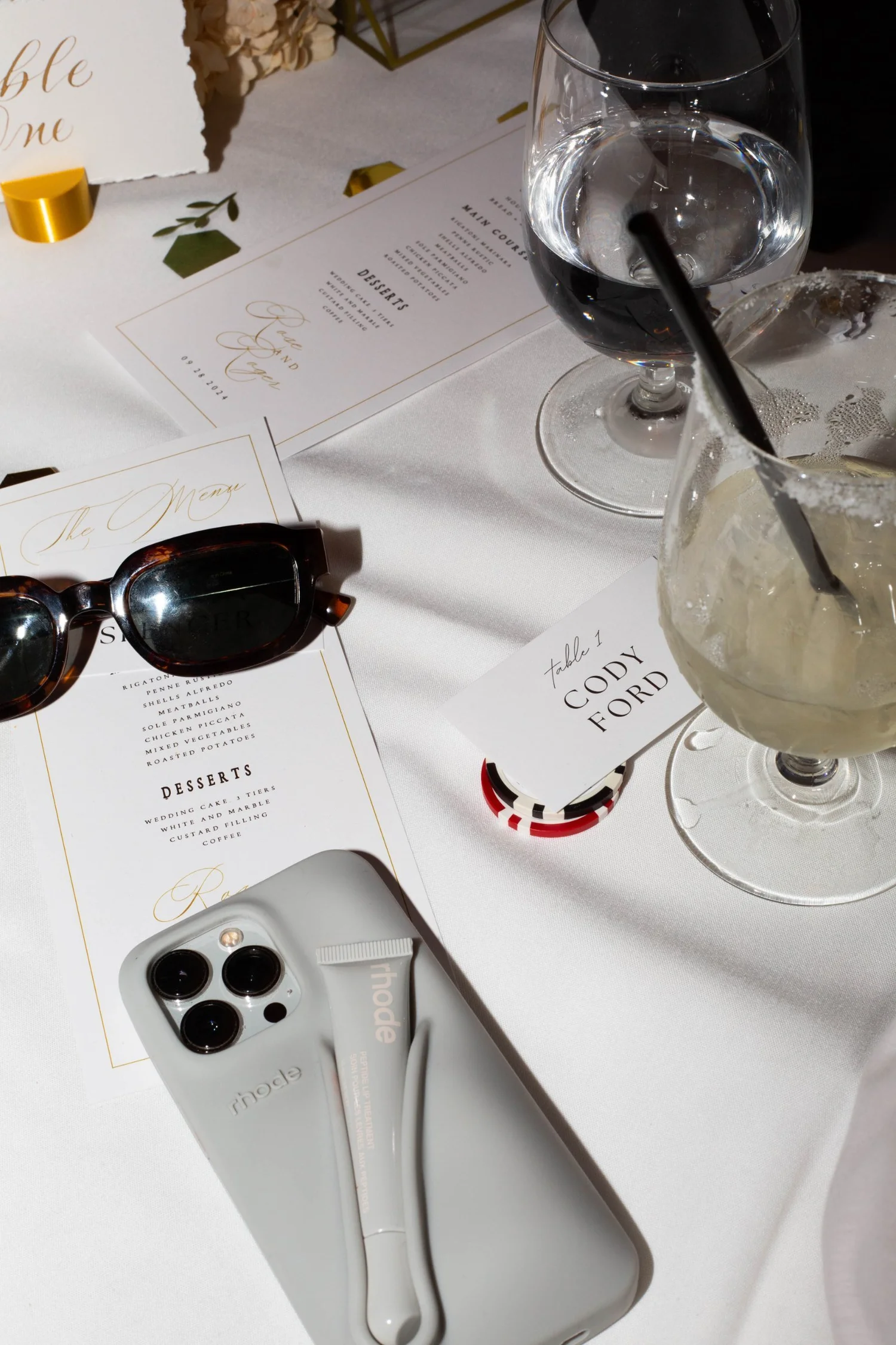 An event table with a menu card, phone and sunglasses