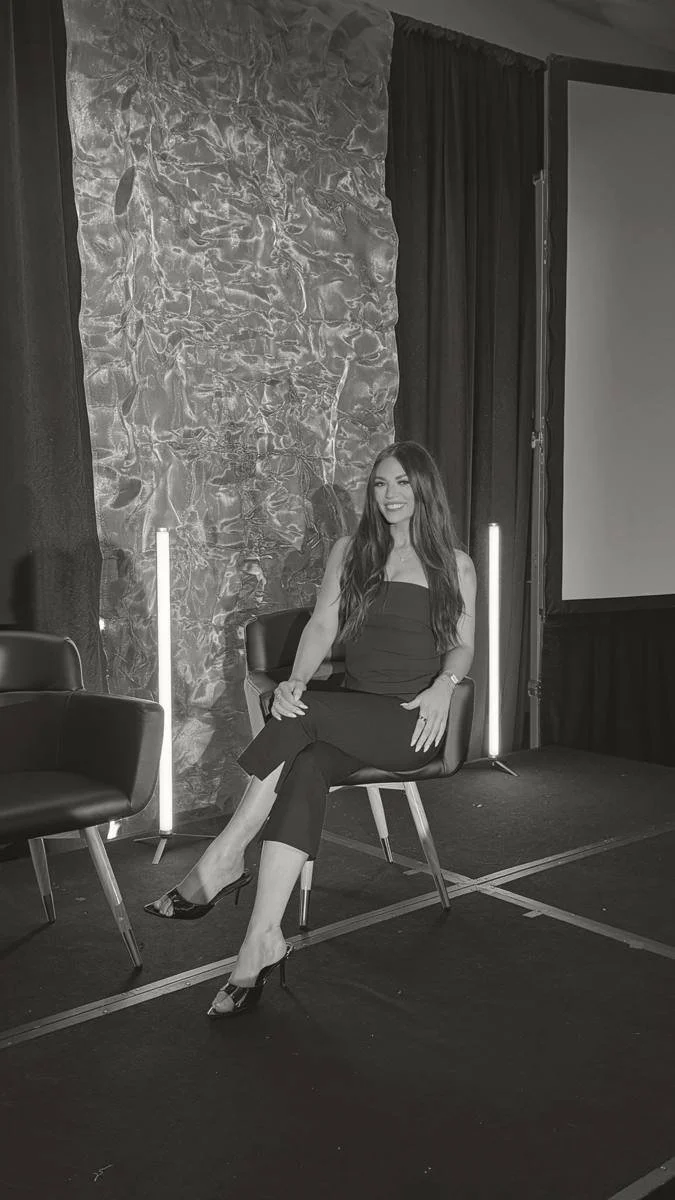Nicole Marcus seated on a panel stage