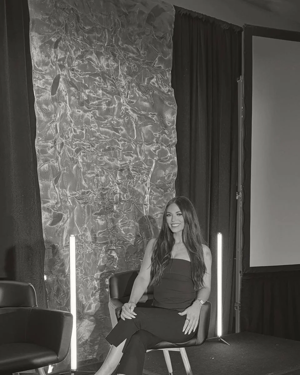 Nicole Marcus seated on a panel stage
