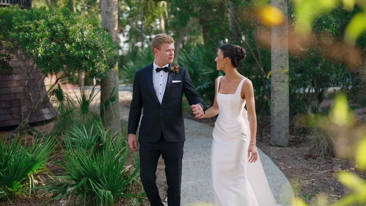 Kelly and Andrew walking hand in hand through the gardens