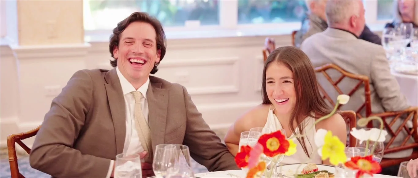 Grace and Nick laughing together during wedding-weekend toasts