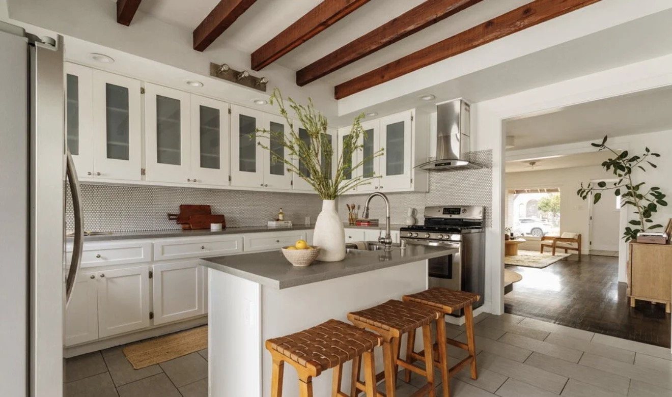 Chef's kitchen with island seating and exposed beams
