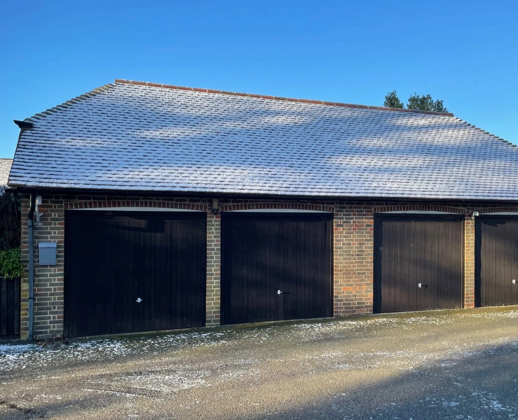 The existing garage group before the conversion and extension, photographed with a light covering of snow.