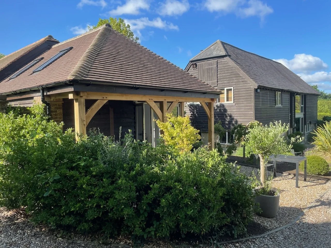 The Granary combines timber-clad buildings, an oak porch and established garden planting.