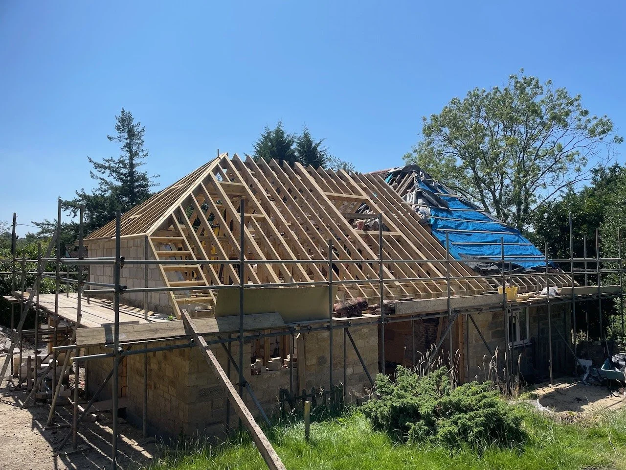 The rear wing during construction, with the new timber roof structure meeting retained building fabric.