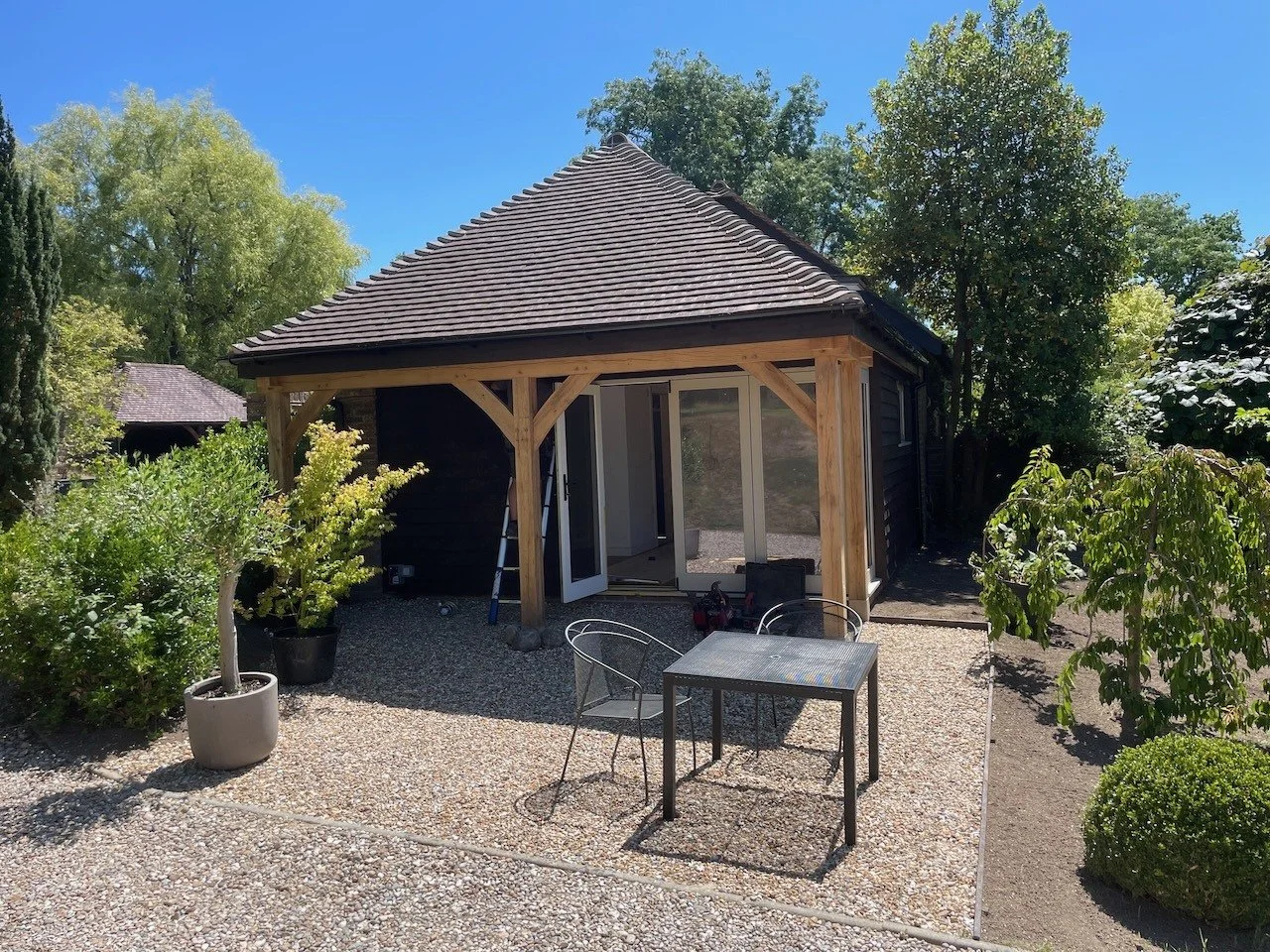The timber-framed covered terrace and gravel sitting area as the extension nears completion.