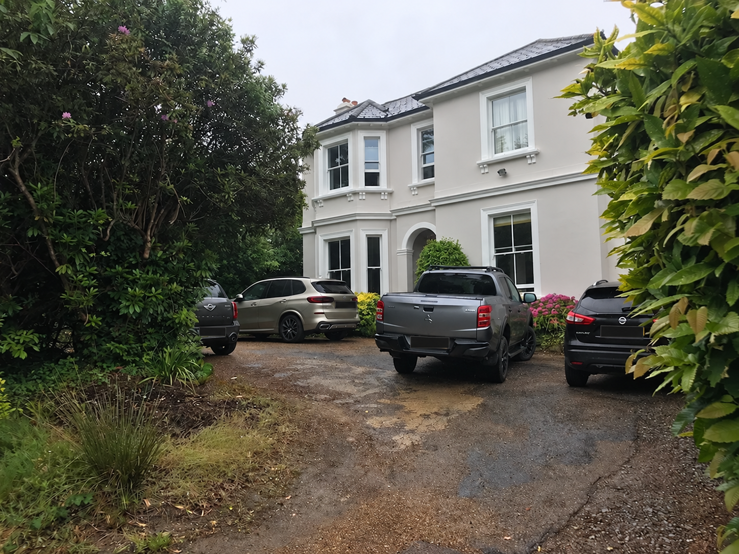 Before: parked cars crowd the uneven front drive at Frant Road, with overgrown planting beside the approach.