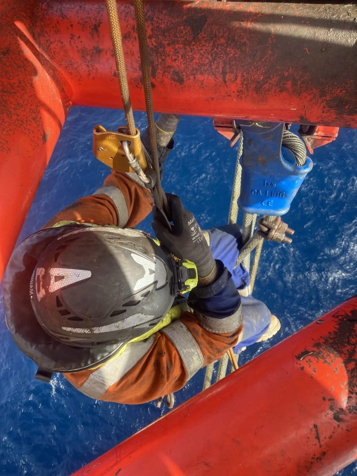 Industrial rope access technician completing coating work